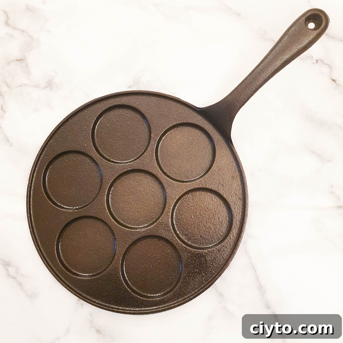 A blini pan with holes to hold the batter.