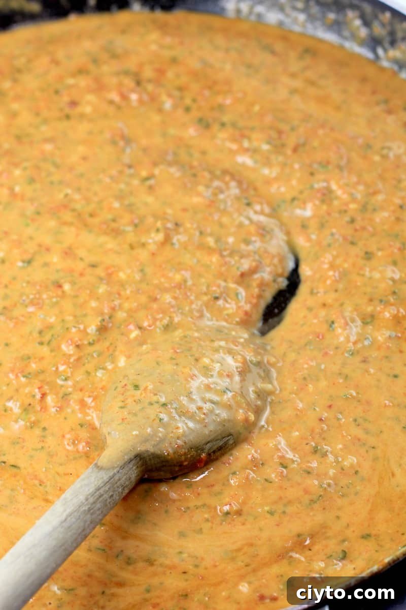 vegan sun-dried tomato pesto sauce in a skillet with wooden spoon