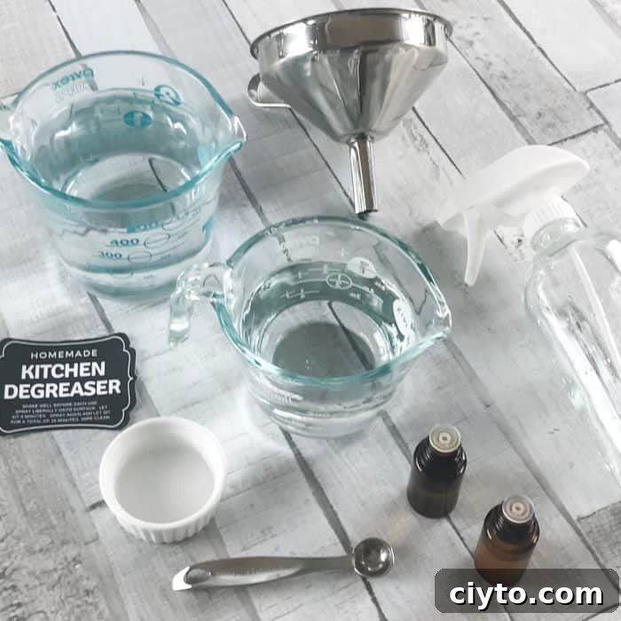 essential oil bottles, printable label, funnel, and other supplies needed to make natural kitchen degreaser