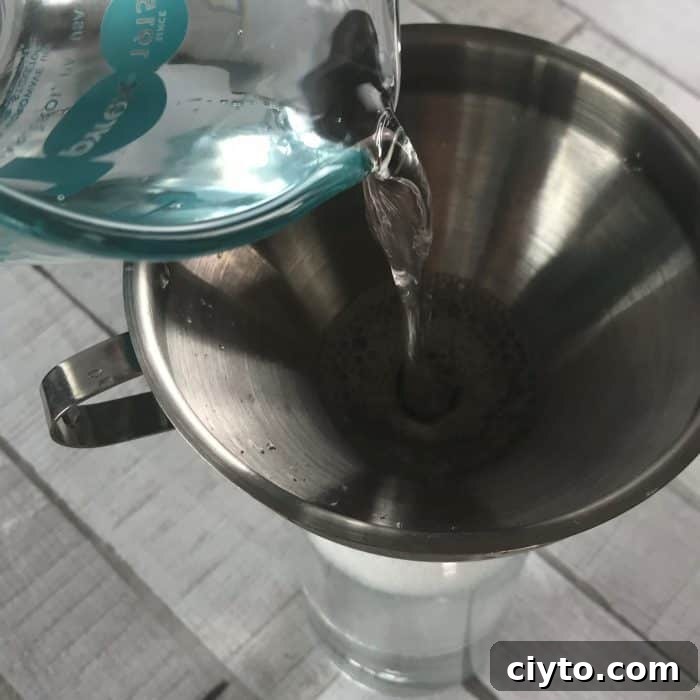 measuring cup adding distilled water to funnel