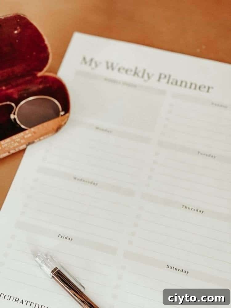 weekly planner print out with a pair of glasses in case next to it on table