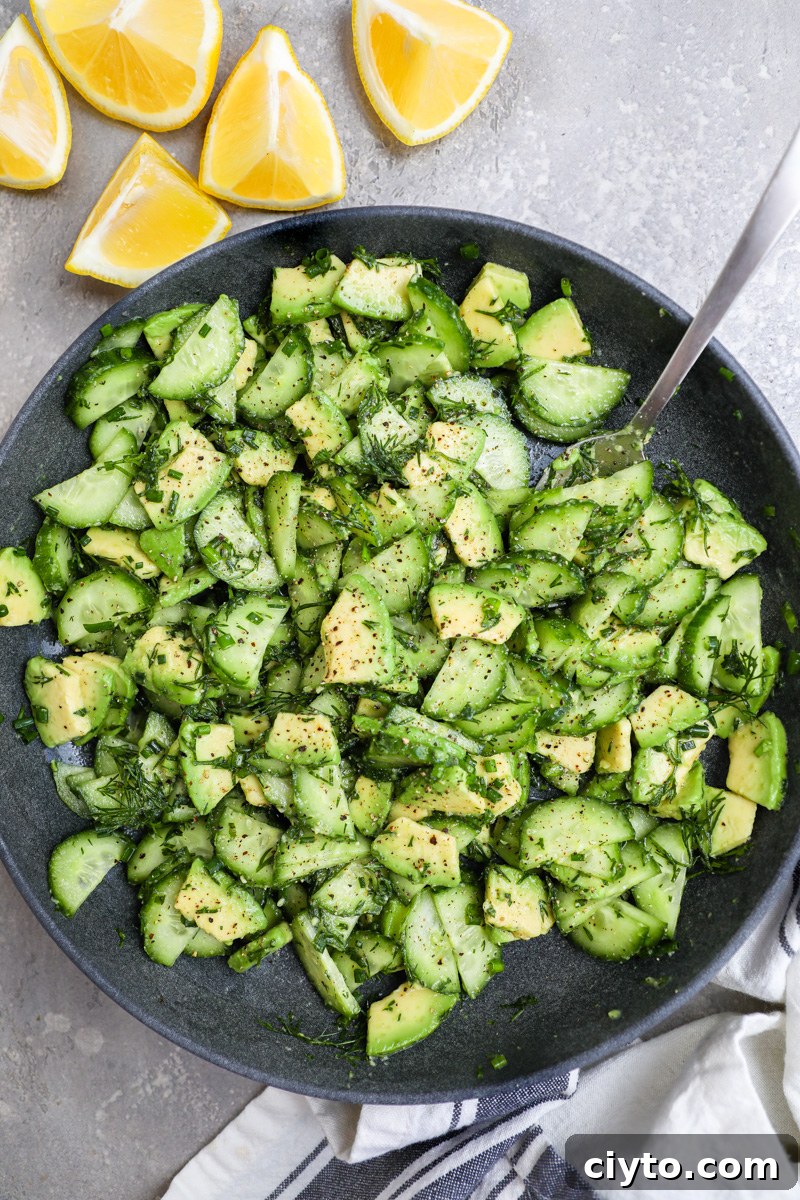 A serving bowl filled with cucumber-avocado salad used as part of a tzatziki chicken bowl