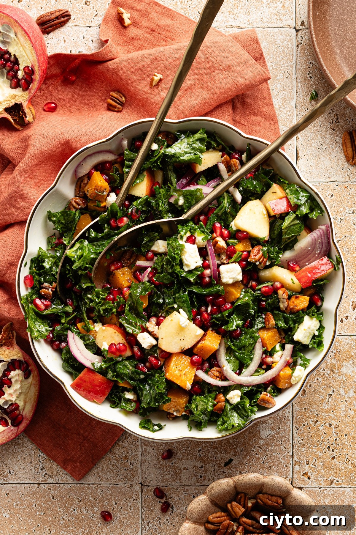 Kale and Butternut Squash Salad with Pomegranate and Apple 8 Kale and butternut squash salad with apple and pomegranate seeds in a large bowl.
