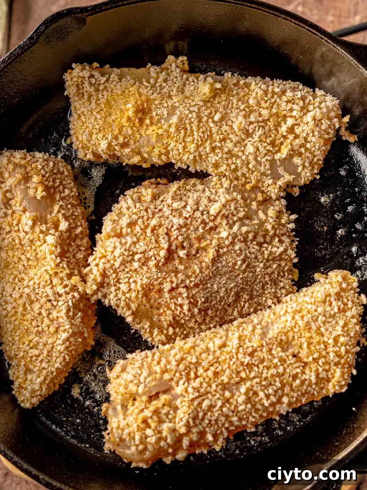 Fish with breadcrumbs in a skillet.