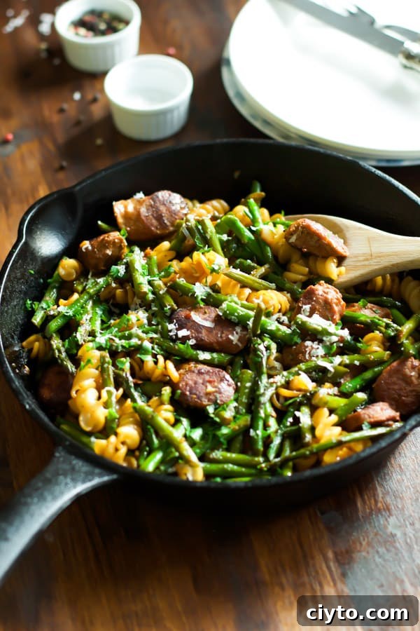 Sausage asparagus quinoa pasta in a cast iron skillet.