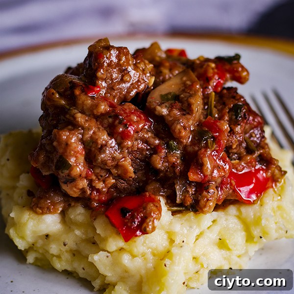 Slow-Braised Tuscan Beef with Garlic Mascarpone Mashed Potatoes 10 A plate of garlic mascarpone mashed potatoes topped with Tuscan Braised Beef.
