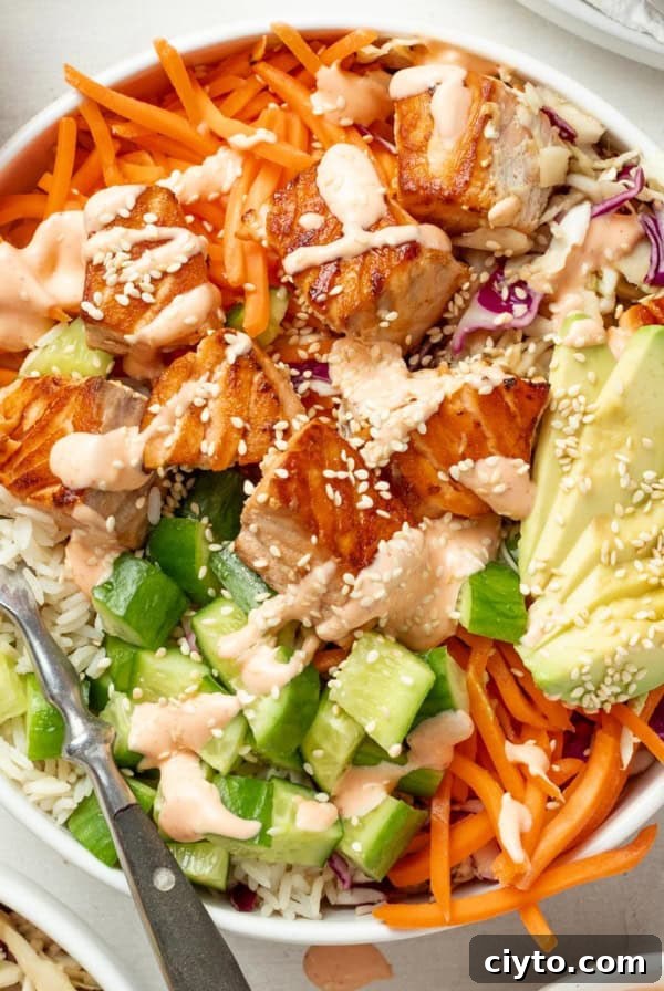Salmon rice bowls topped with spicy mayo and sesame seeds.