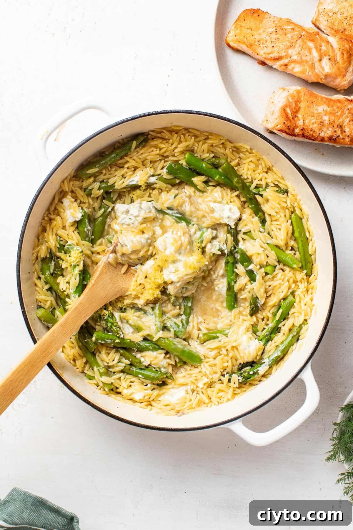 Stirring the orzo with a wood spoon after cooking.