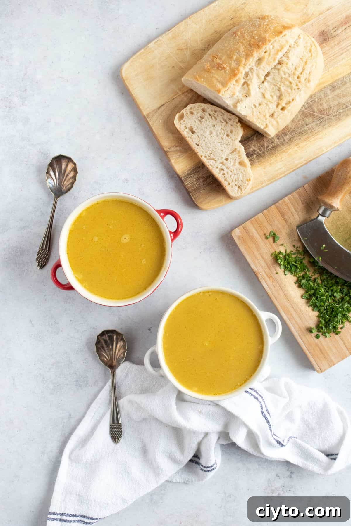 Two bowls of soup with crusty bread.