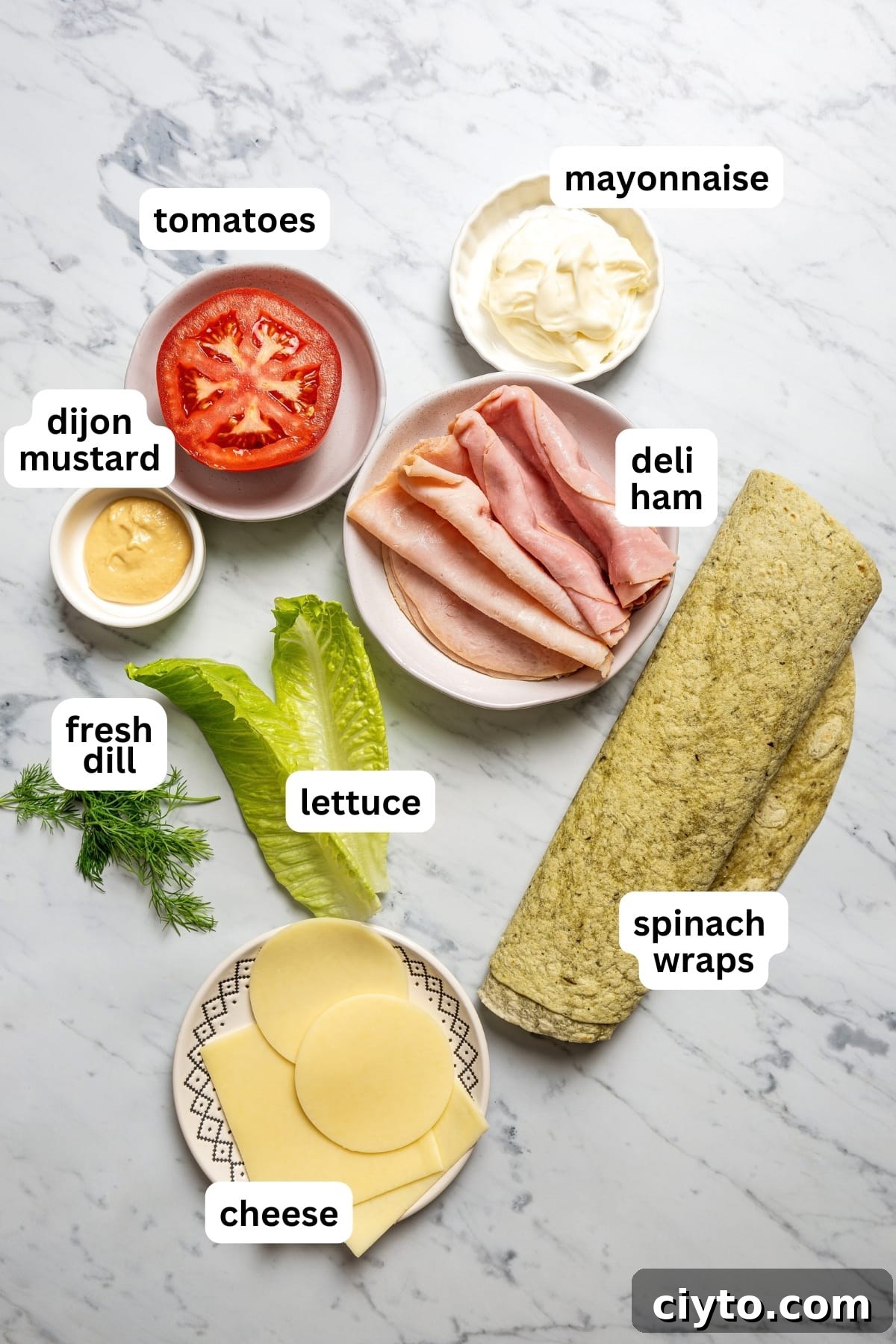 Pinwheel sandwiches are loaded with sliced meats, cheeses, vegetable matter, and dijon-dill mayo and sliced into perfect 2-bite morsels. An image of all the ingredients for pinwheel sandwiches.