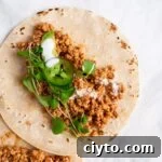 Quick Vegan Tofu Tacos Recipe for Weeknights 5 a close up view of a tofu taco topped with micro greens and jalapeno slices.