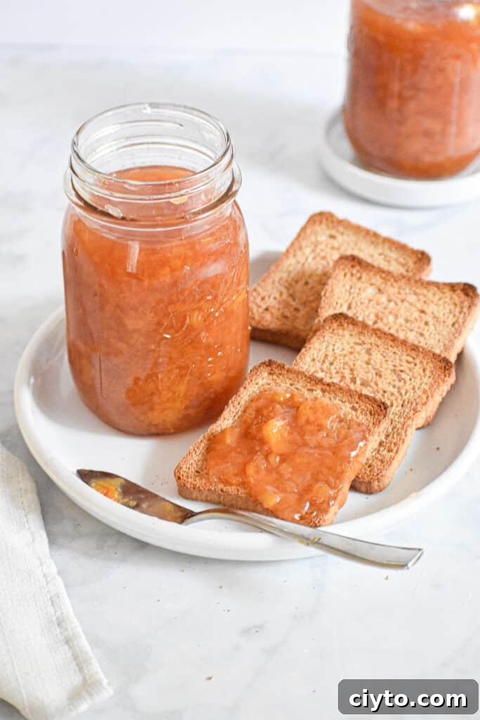 Homemade Instant Pot Peach Jam Recipe 8 A jar of peach jam surrounded by toast
