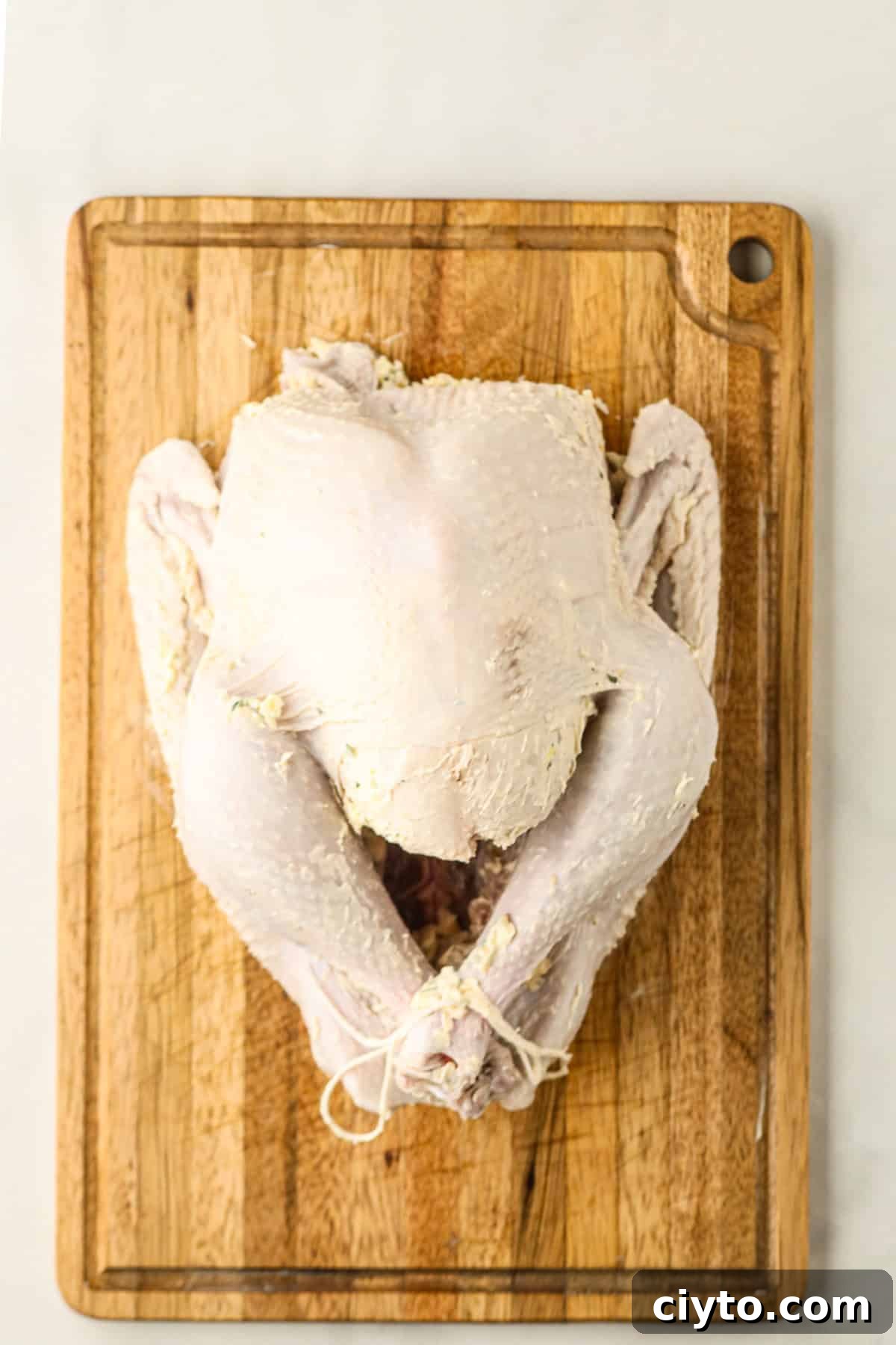 Overhead picture of turkey with butter and seasoning rub on it.
