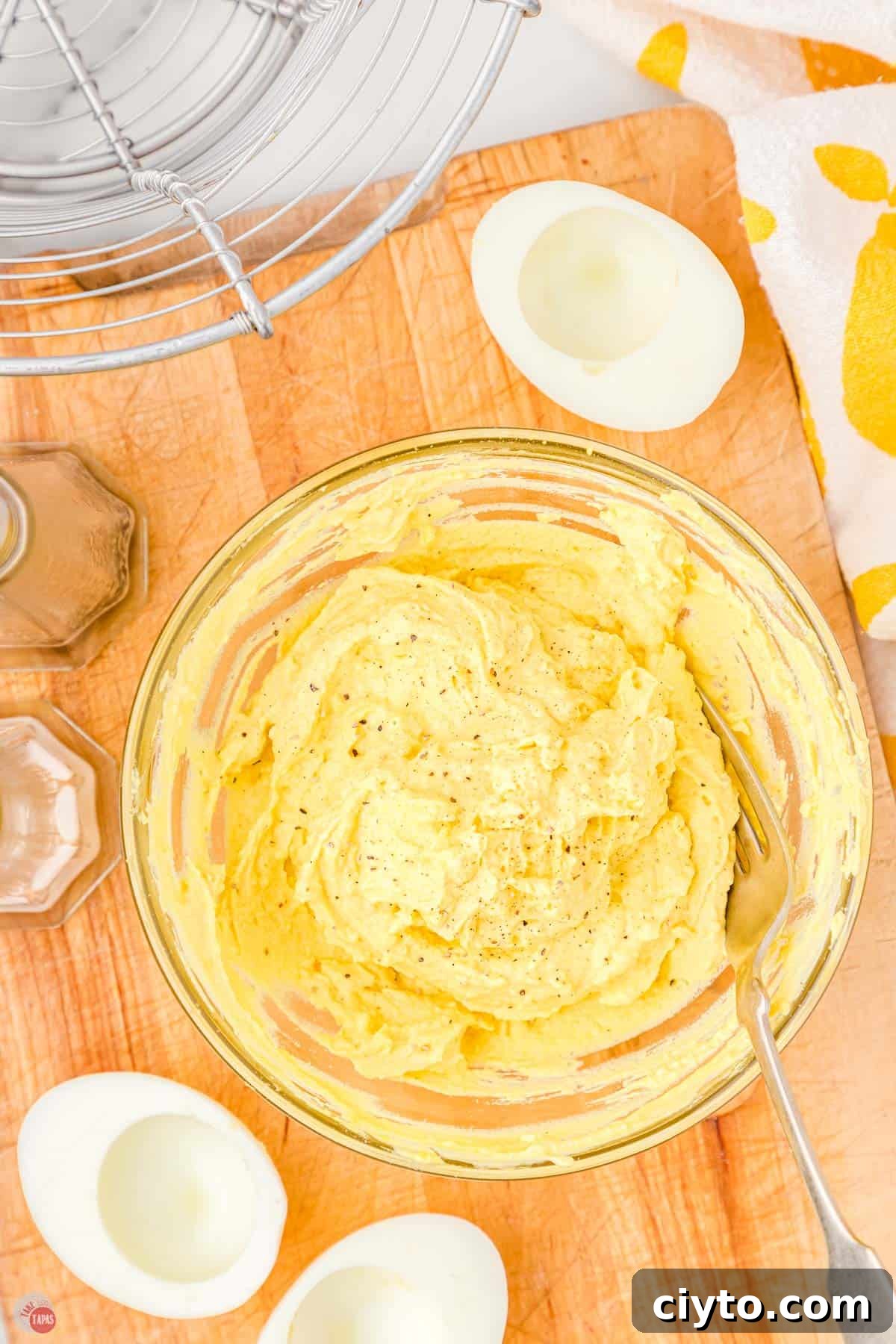 Classic Deviled Eggs Recipe for Parties and Holidays 5 mixture of egg yolks and mayo in a clear bowl with a fork
