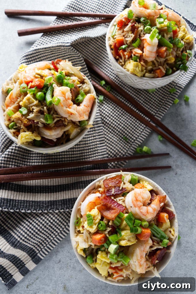 Three bowls of shrimp fried rice cooked on a Blackstone grill.