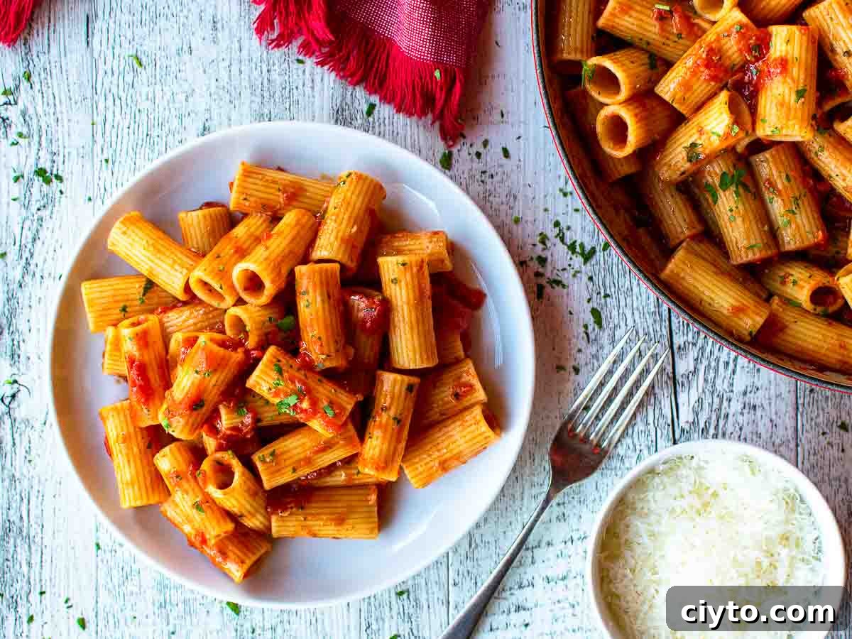 Pasta with tomato sauce on a white plate viewed from above.