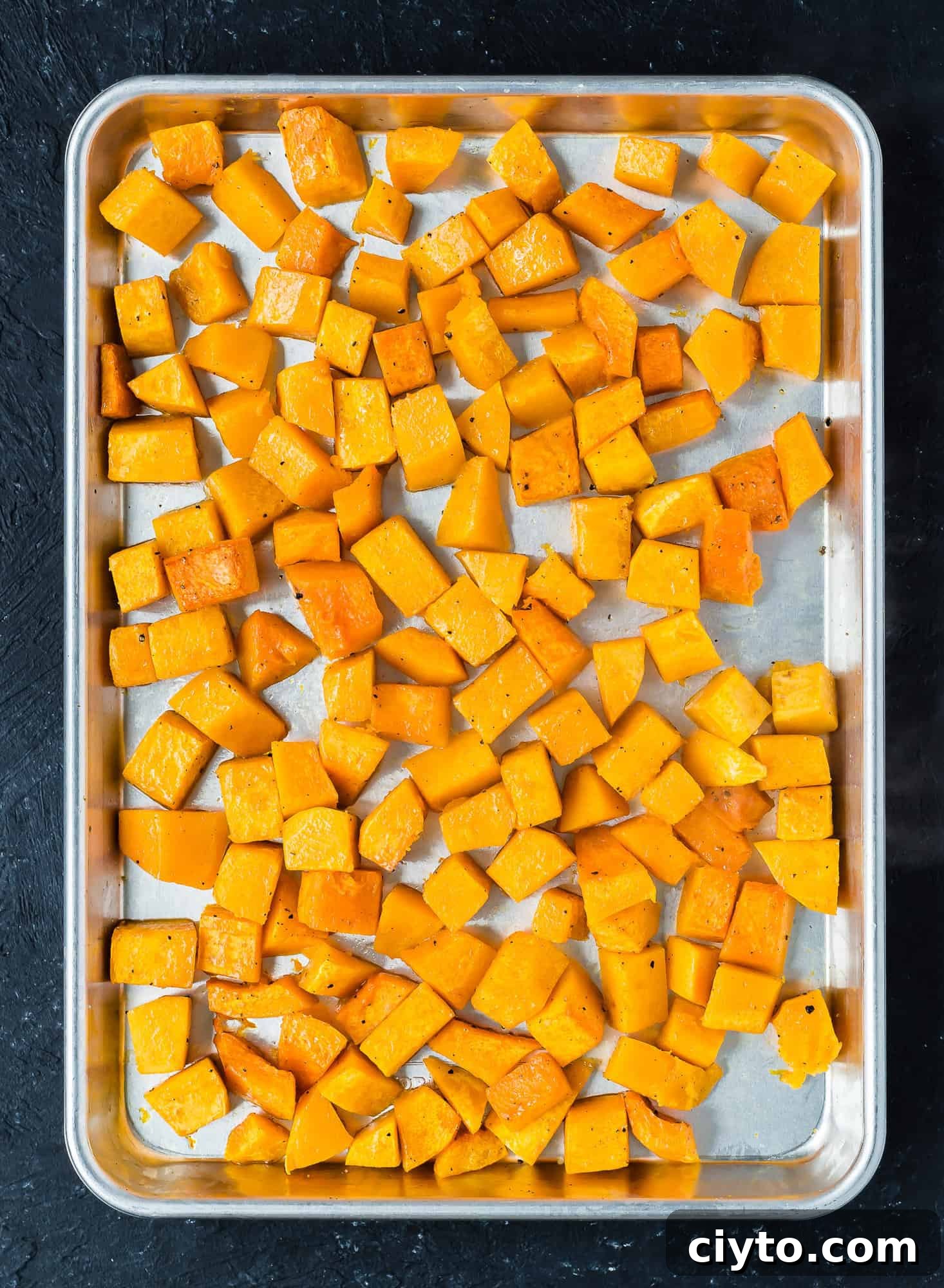 Diced roasted butternut squash on a sheet pan.