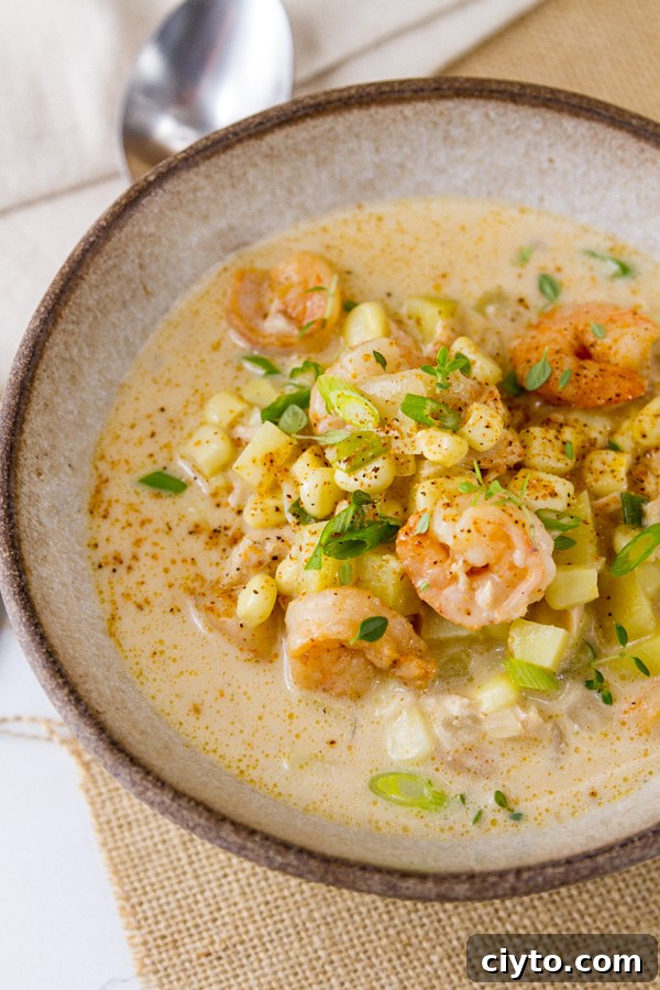a white bowl with a spoon to serve Cajun Seafood chowder 