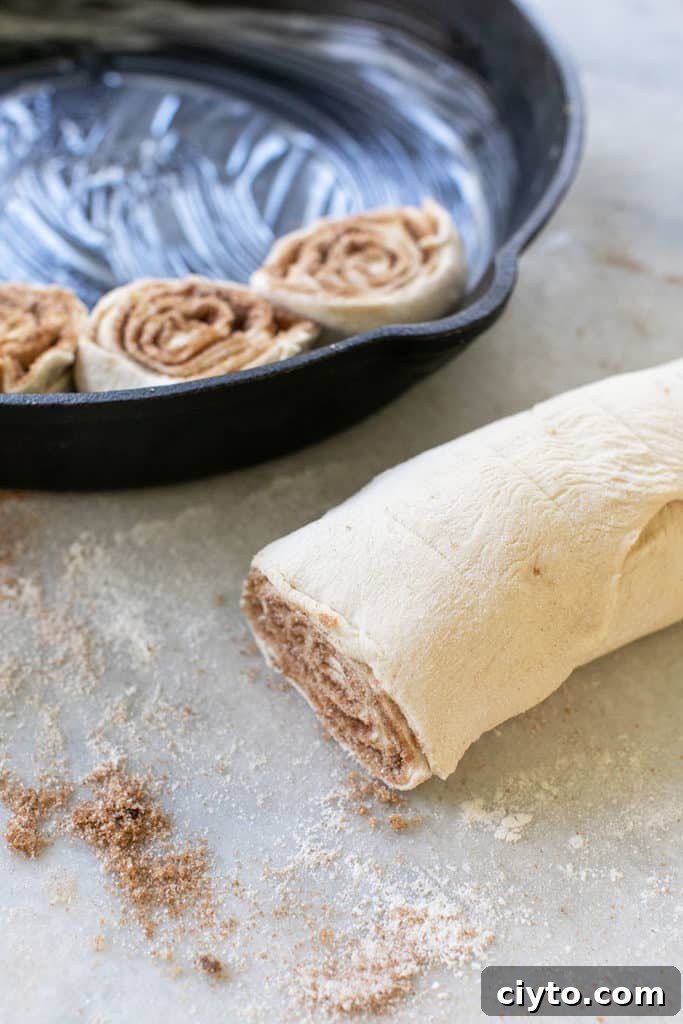 Preparing to cut cinnamon rolls to bake in a cast iron skillet.