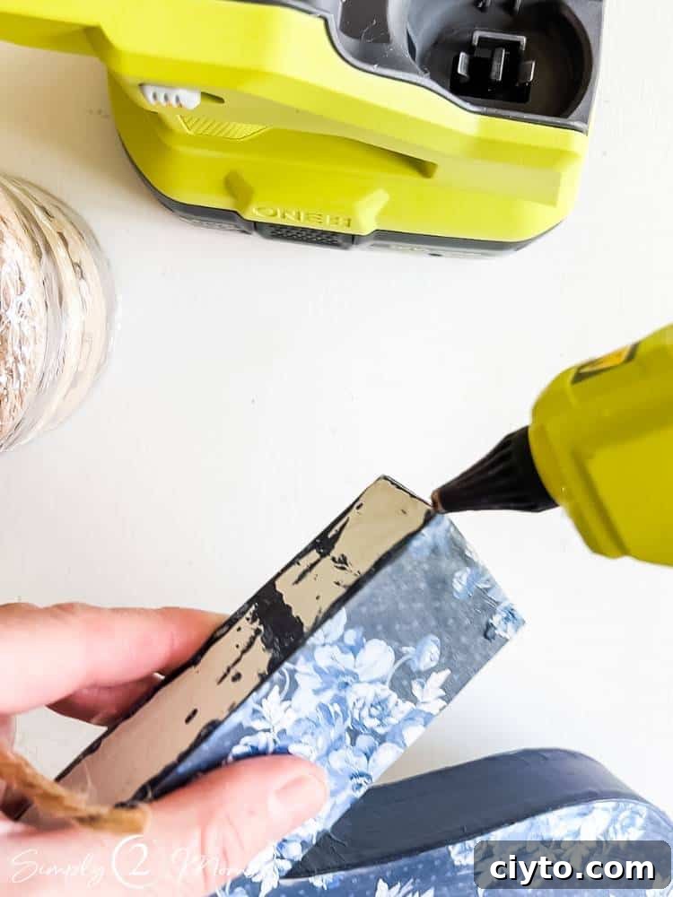 adding glue with glue gun to edge of number