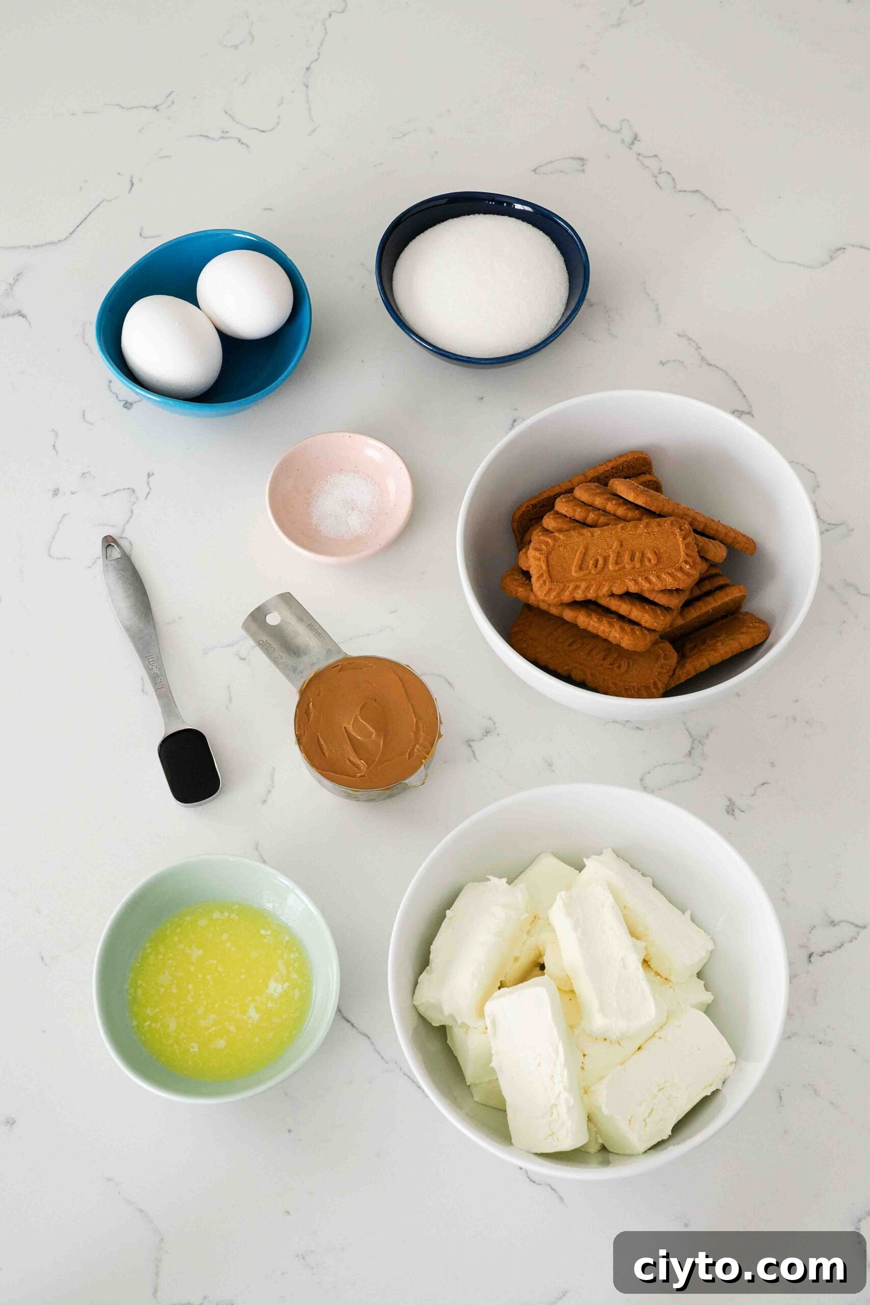 Mini Biscoff Cheesecakes Recipe with Cookie Butter Crust 3 Ingredients for mini Biscoff cheesecakes on a quartz countertop.