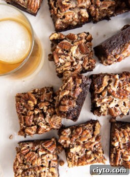 pecan pie brownies on wax paper next to glass of bourbon.