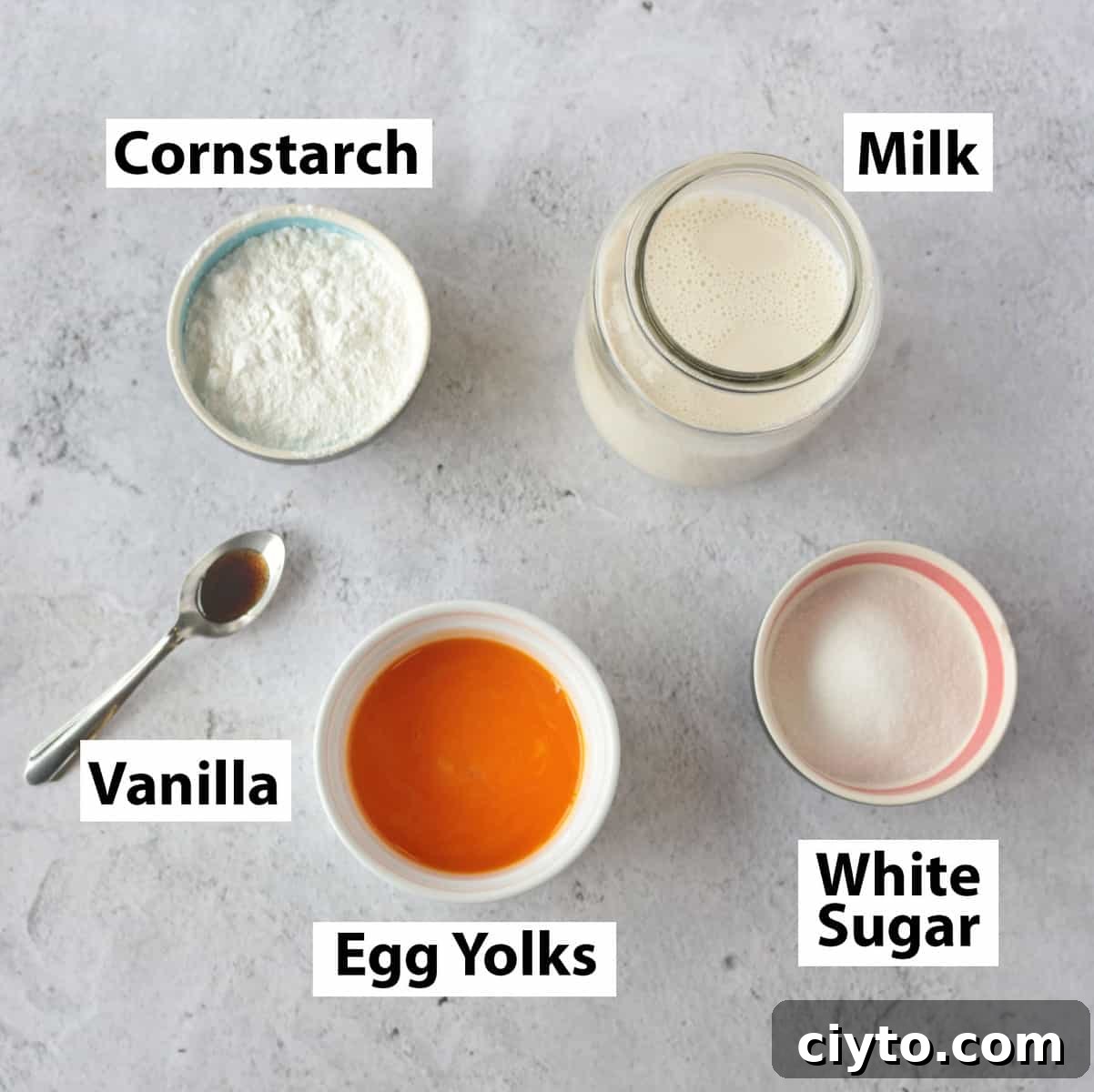 Ingredients for Creme Patissiere on a grey surface.