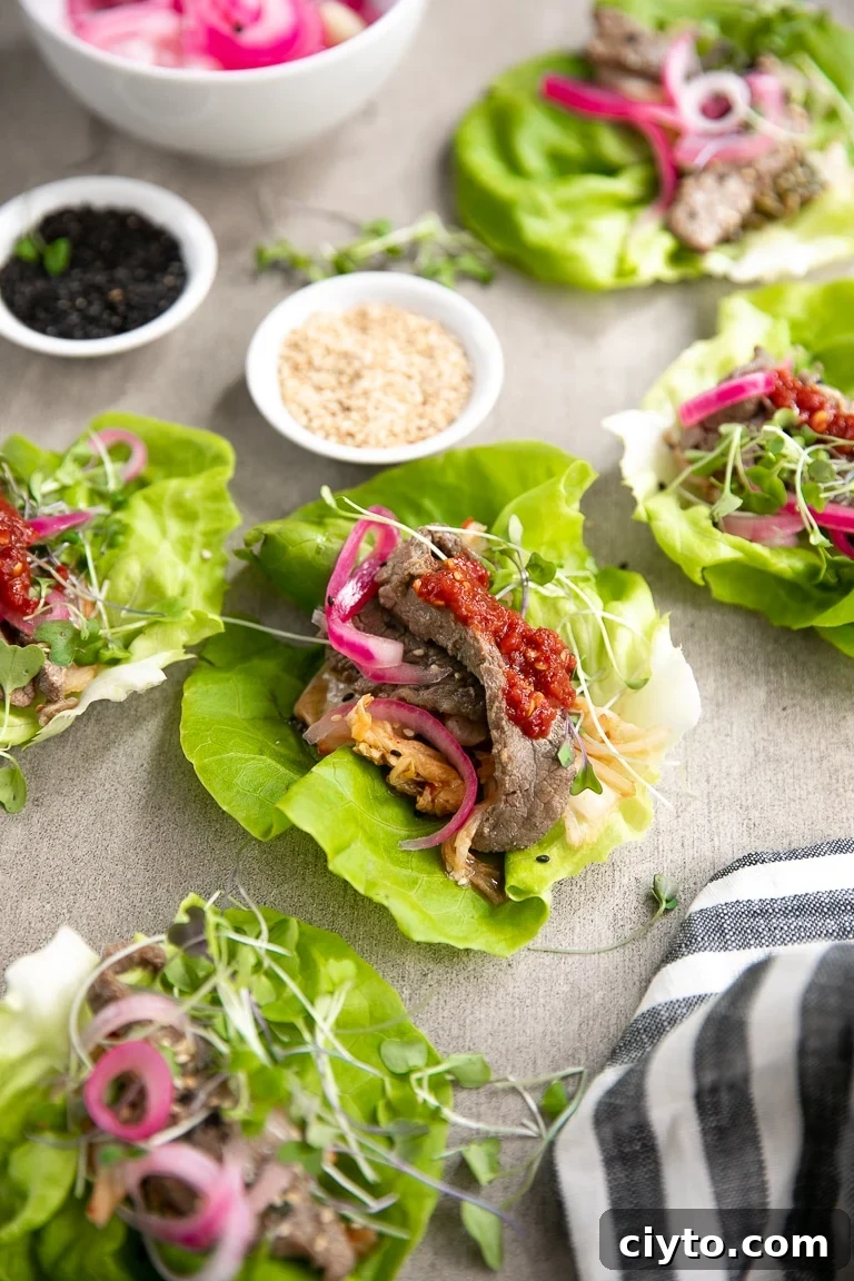 How to Make Korean Bulgogi Beef Lettuce Wraps 6 Bulgogi Beef Lettuce Wraps topped with pickled red onions, kimchi, and micro greens.