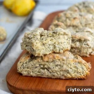 Lemon Poppy Seed Sourdough Scones Recipe 15 Lemon poppyseed sourdough scones stacked on a wooden board with a soft, tender crumb.