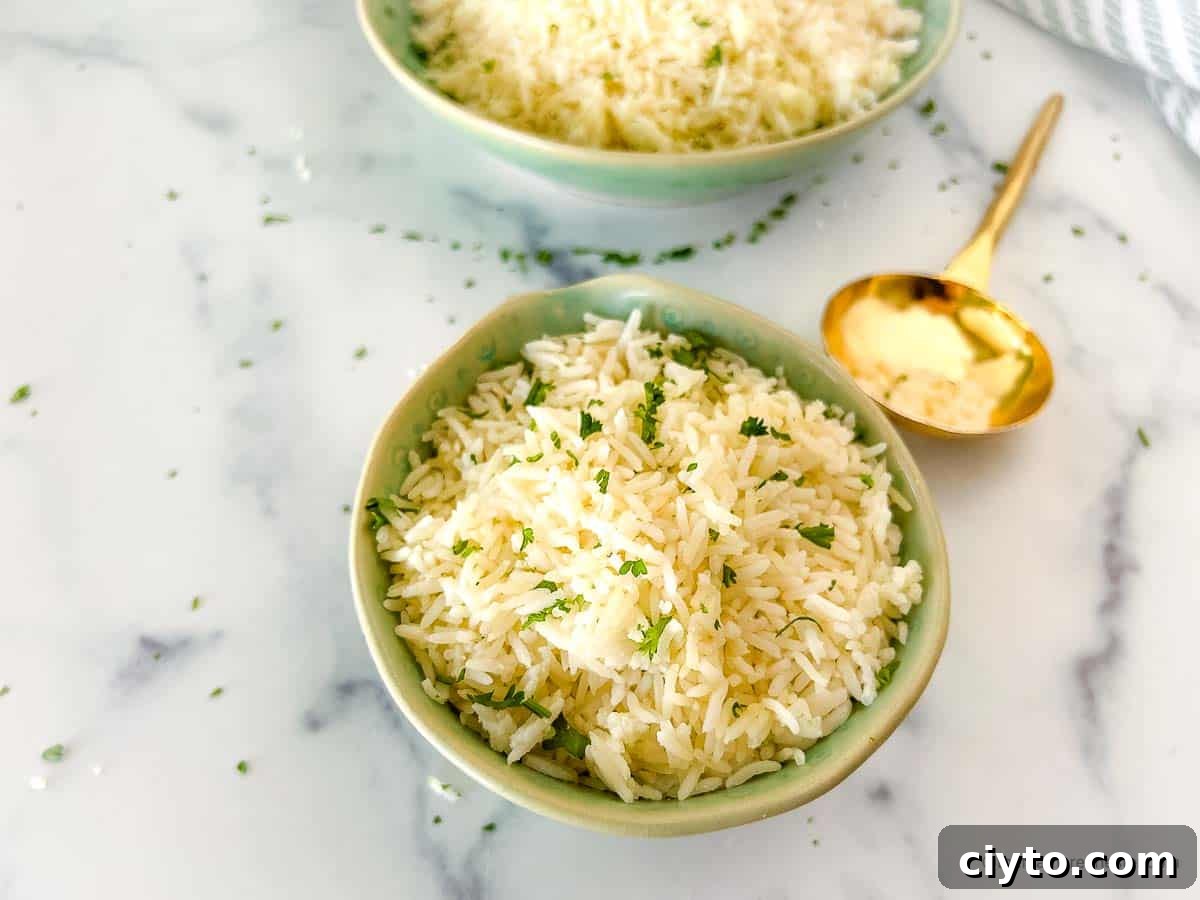 Coconut milk rice in a green bowl next to a gold serving spoon.