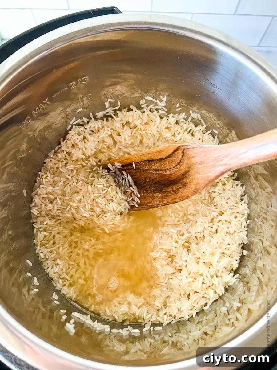 Using wooden spoon to stir broth into a pressure cooker of grains.