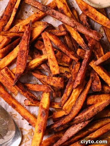 Cajun oven baked sweet potato fries on a wooden cutting board.