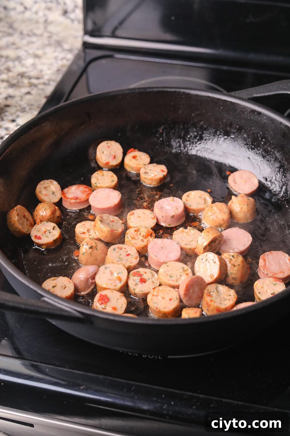 One-Pot Shrimp and Sausage Jambalaya Recipe 4 Sausage cooking in a skillet.