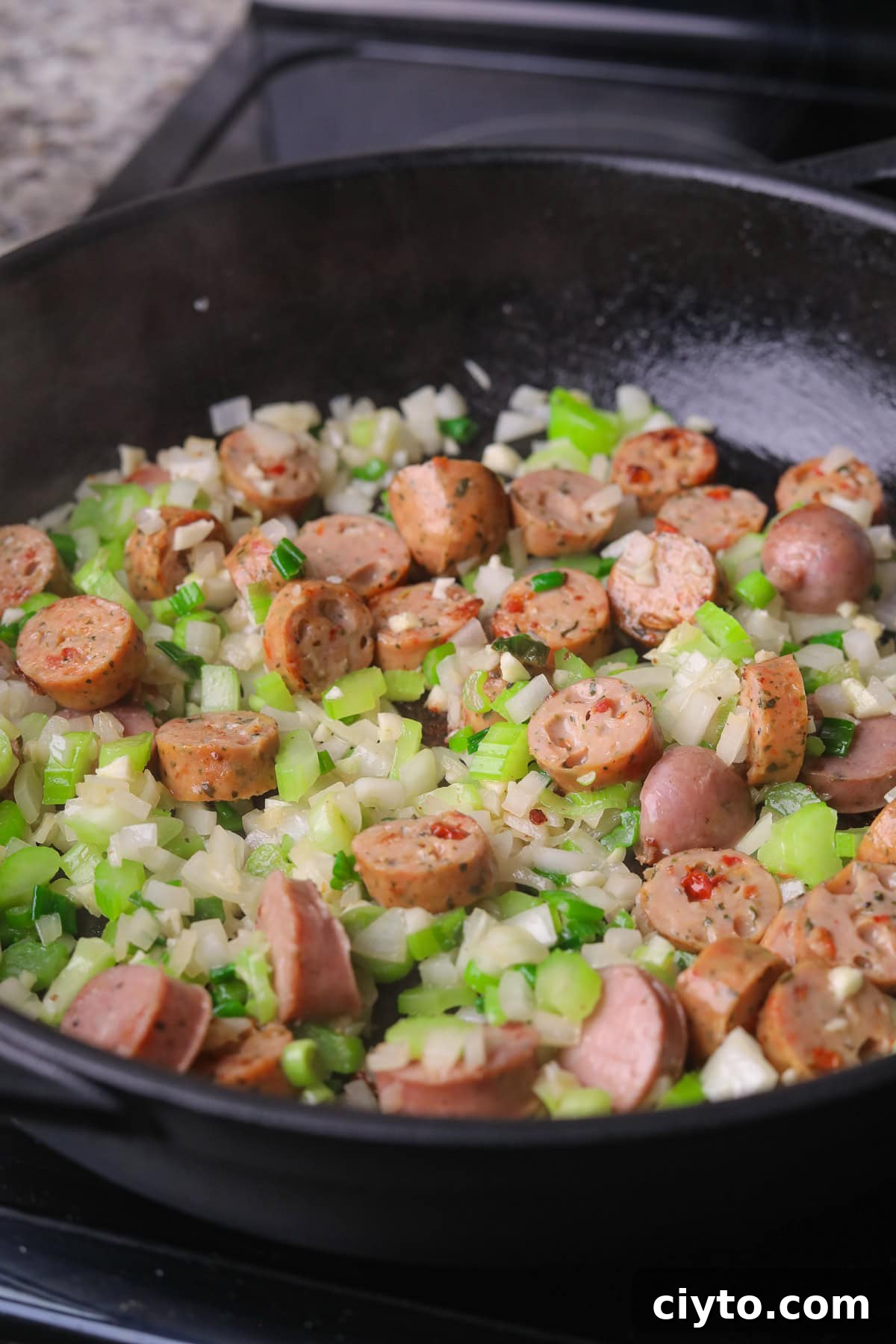 One-Pot Shrimp and Sausage Jambalaya Recipe 5 Sausage and chopped veggies cooking in a skillet.
