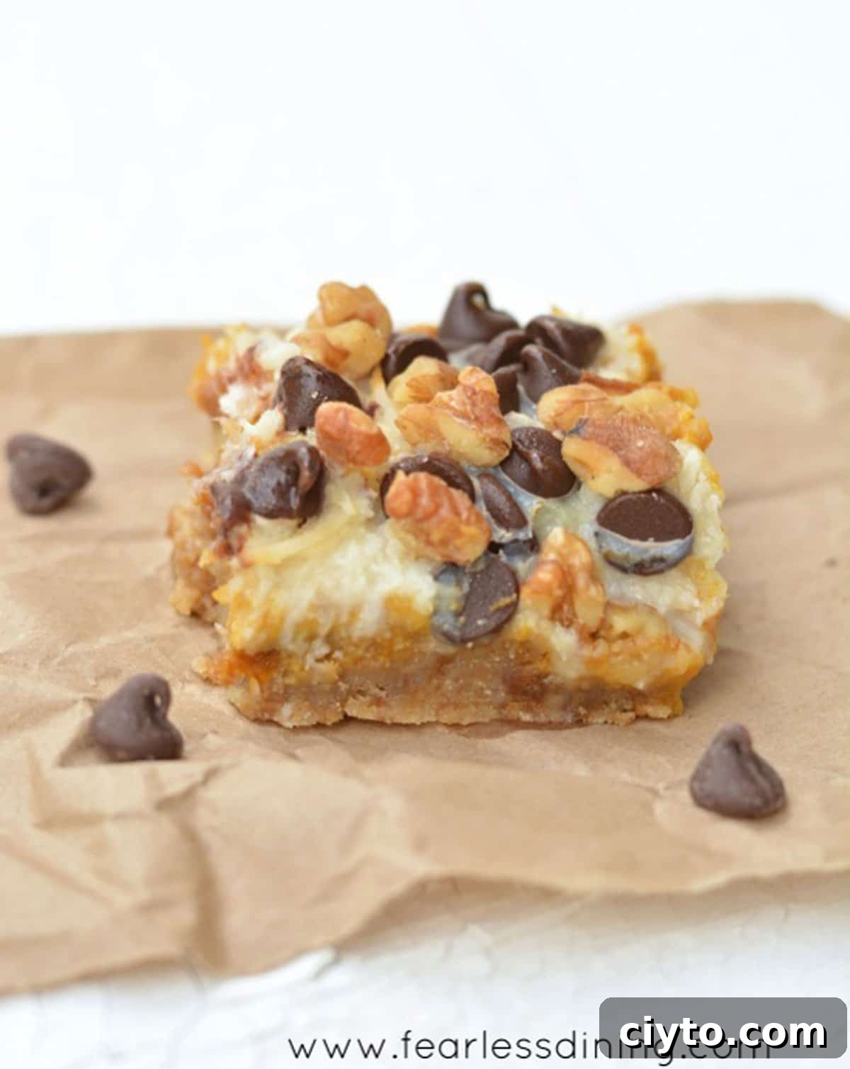 A gluten-free pumpkin 7 layer bar on a piece of brown paper bag.