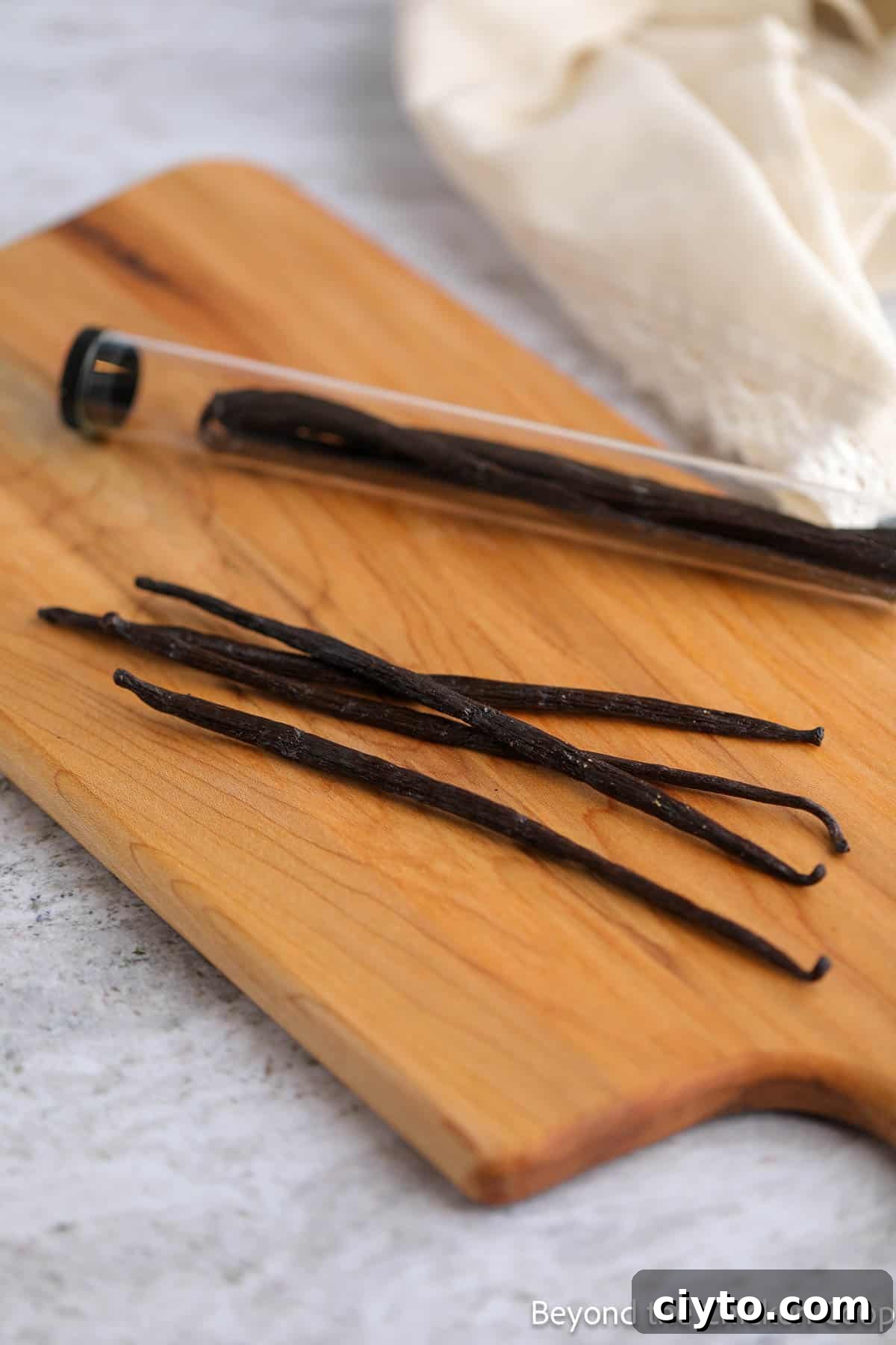 Vanilla beans on a wooden cutting board.