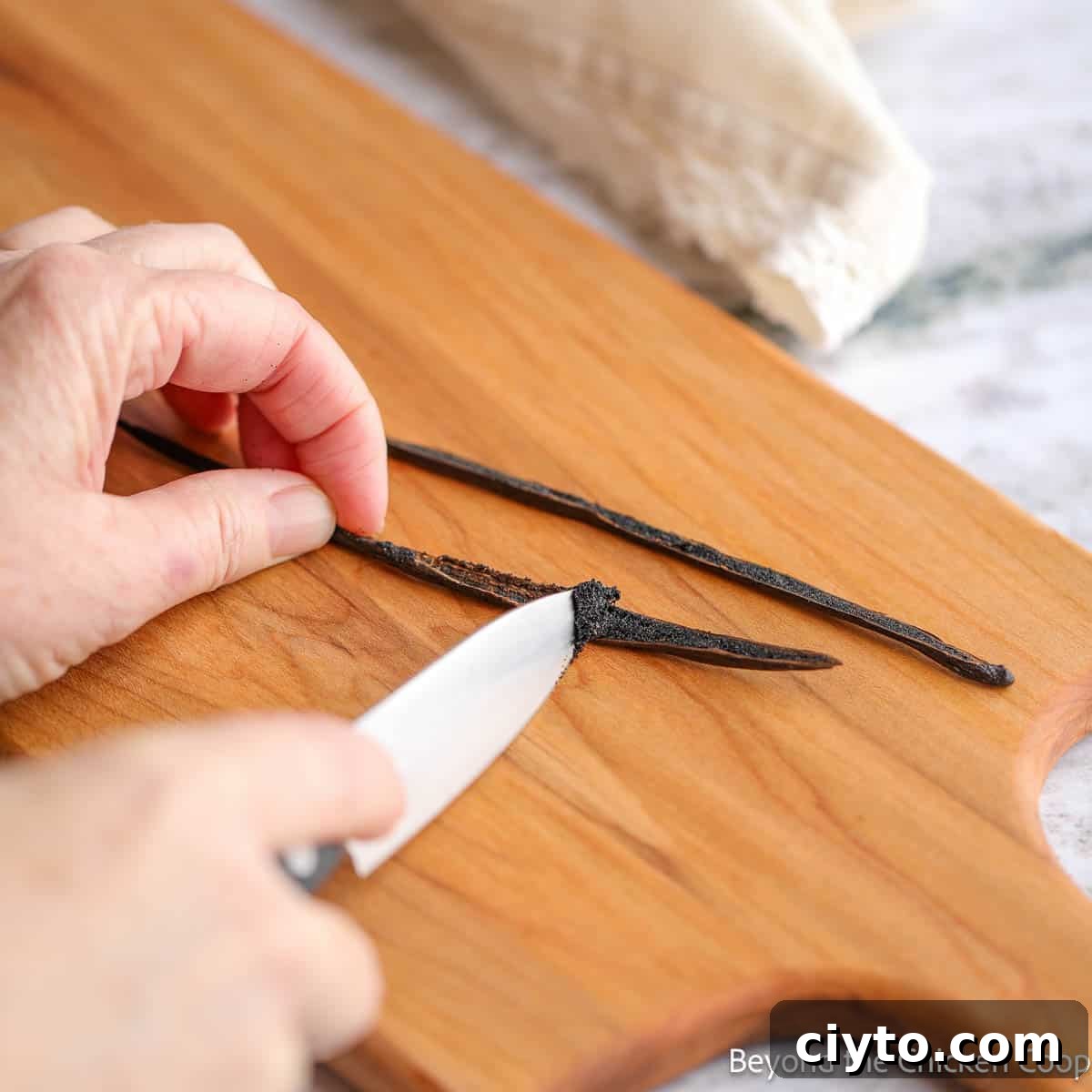 Scraping a vanilla bean with a small knife.