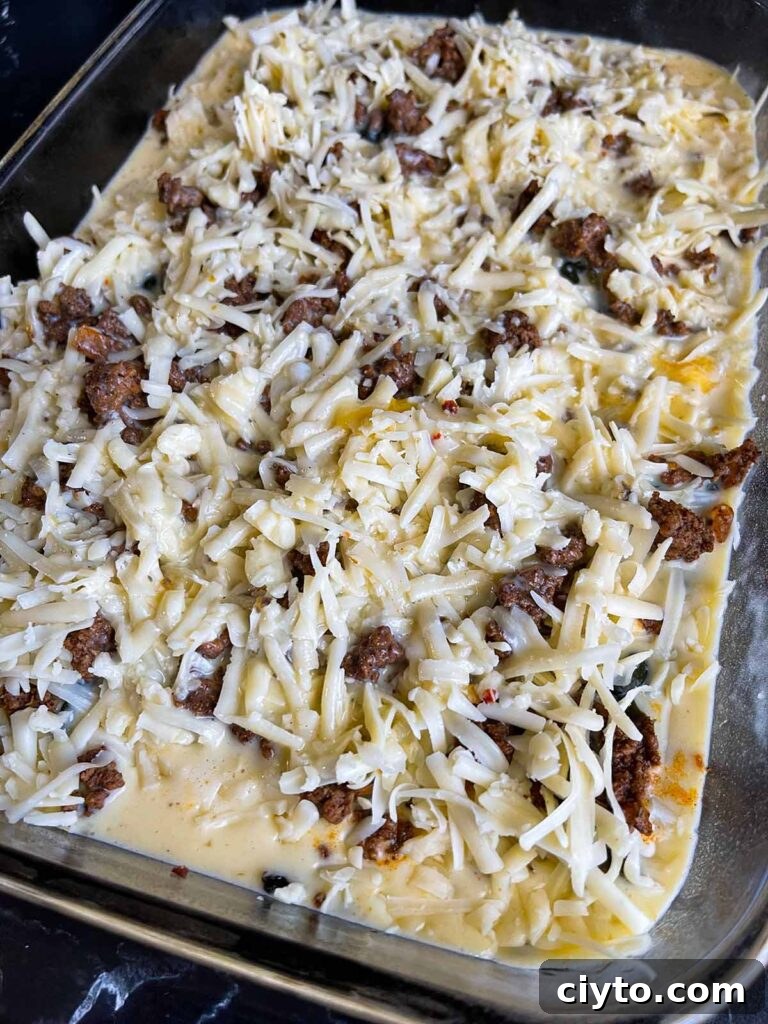 Chile relleno casserole in glass baking dish ready to be baked.