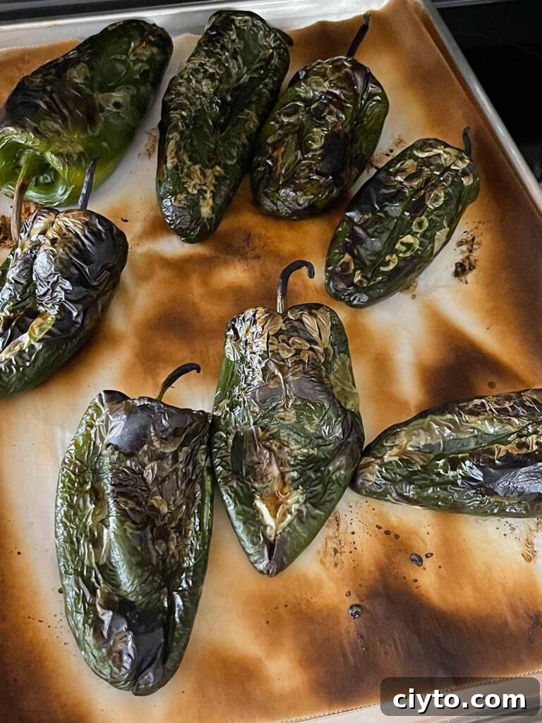 Roasted poblano peppers on a baking sheet.