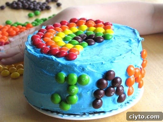 Mini Rainbow Layer Cake Recipe for Birthday Parties 3 blue cake with skittles candy rainbow on top