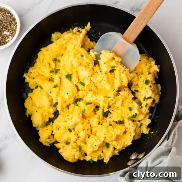 An overhead image of cottage cheese scrambled eggs cooked on a skillet.