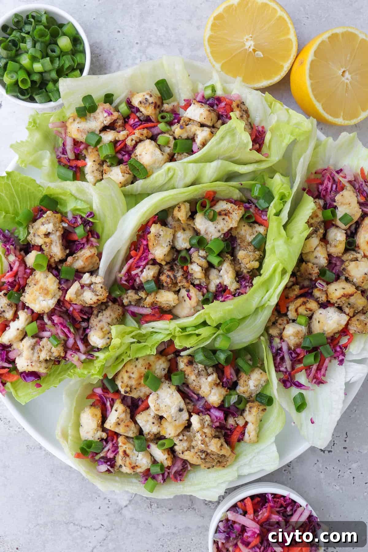 Lemon pepper tofu in lettuce wraps with slaw. Lemons, spring onions on the side.