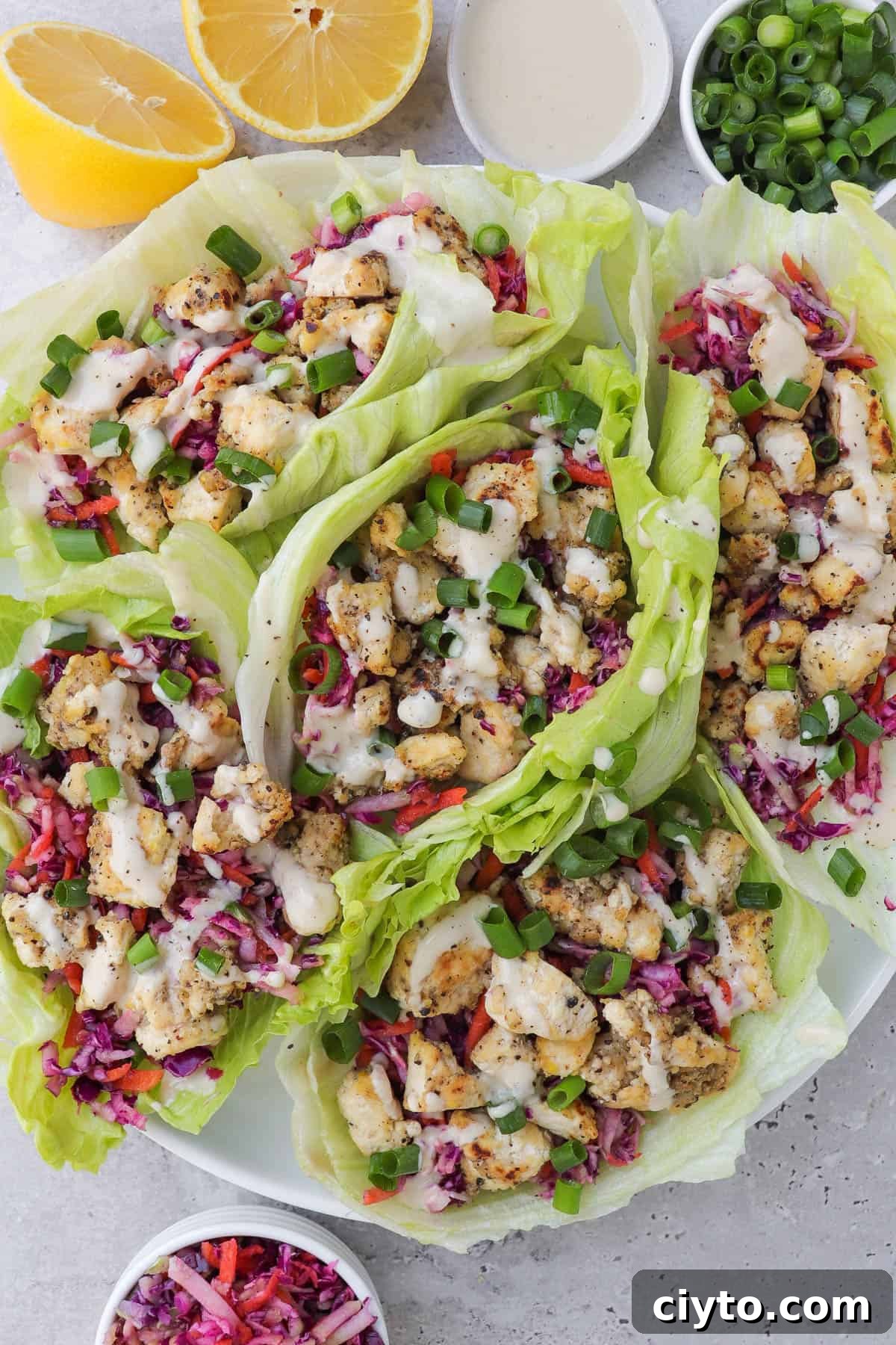 Lemon pepper tofu in lettuce wraps with slaw and tahini sauce.