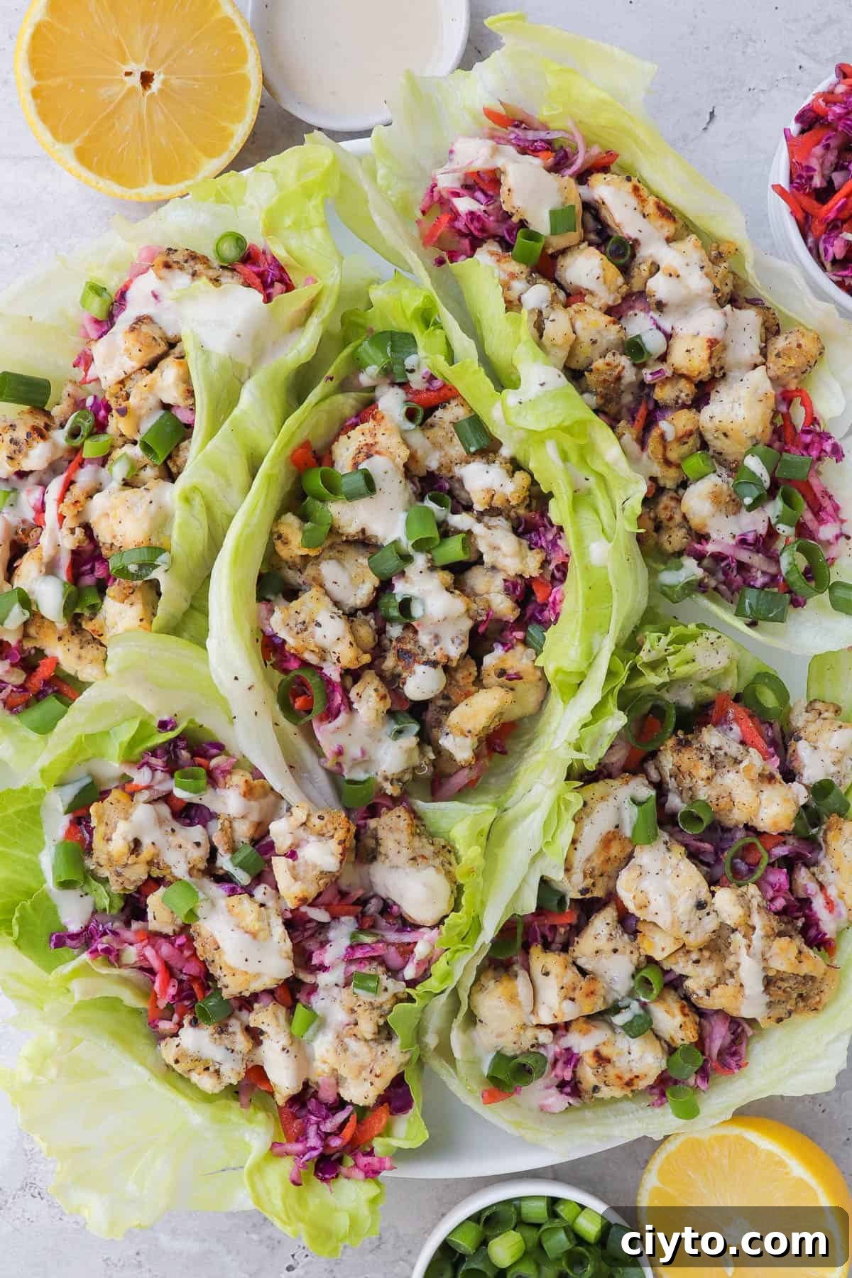 Lemon pepper tofu in lettuce wraps with slaw and tahini sauce.