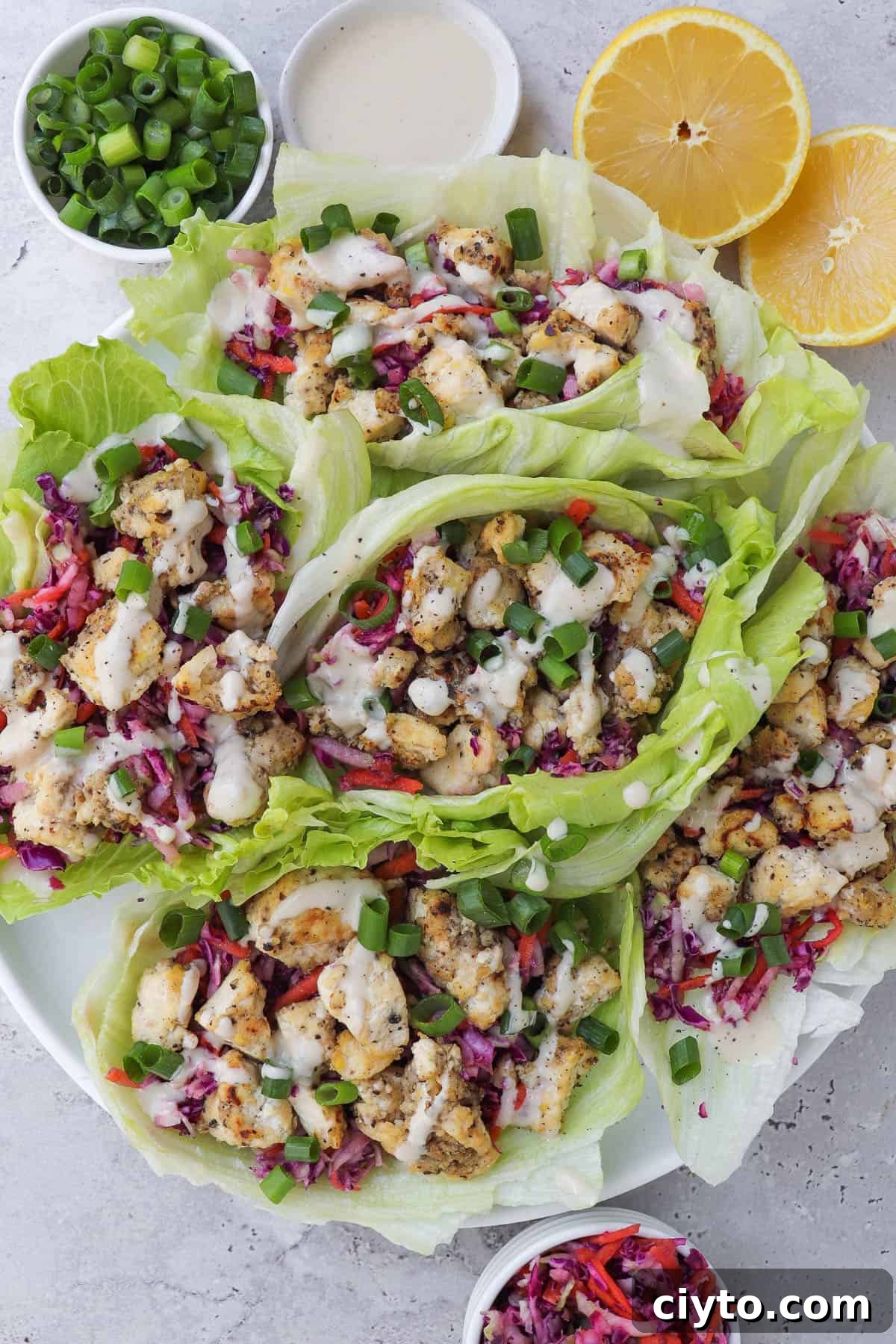 Lemon pepper tofu in lettuce wraps with slaw and tahini sauce.