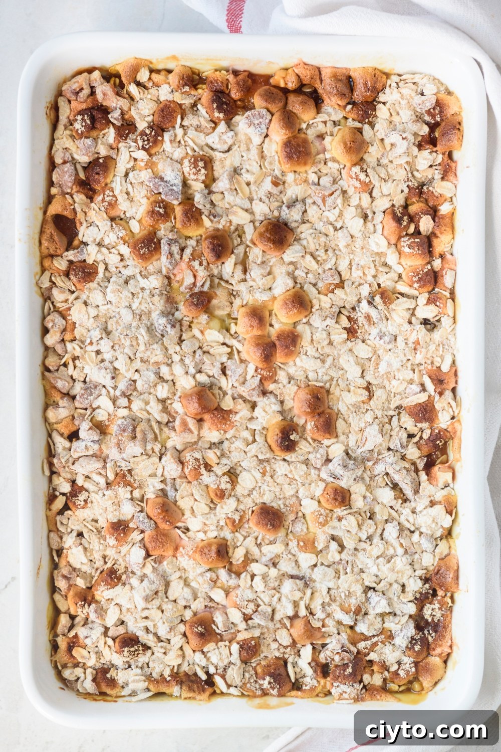 Copycat Boston Market Sweet Potato Casserole Recipe 11 A fully cooked sweet potato casserole in a white casserole dish.