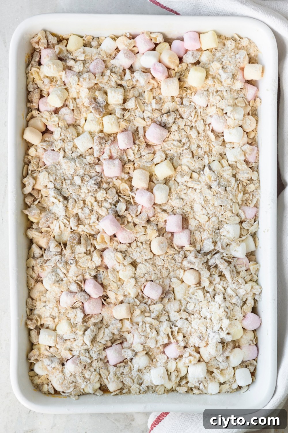 Copycat Boston Market Sweet Potato Casserole Recipe 10 A white casserole dish full of Boston Market Sweet Potato Casserole topped with oat crumble and mini marshmallows.