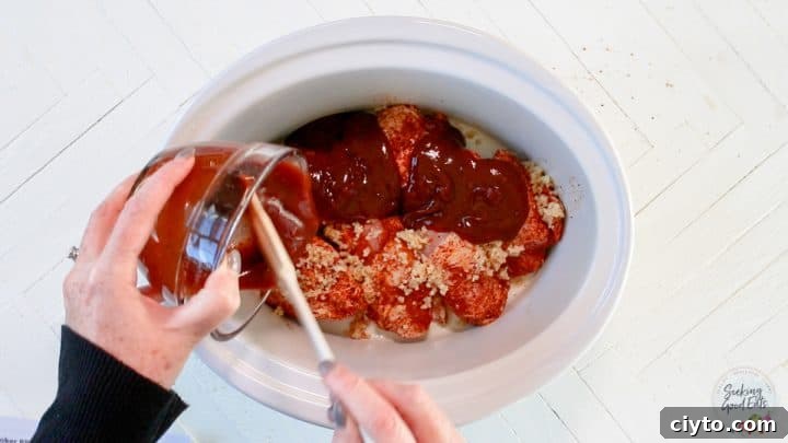 Adding all the ingredients to a white oval slow cooker.