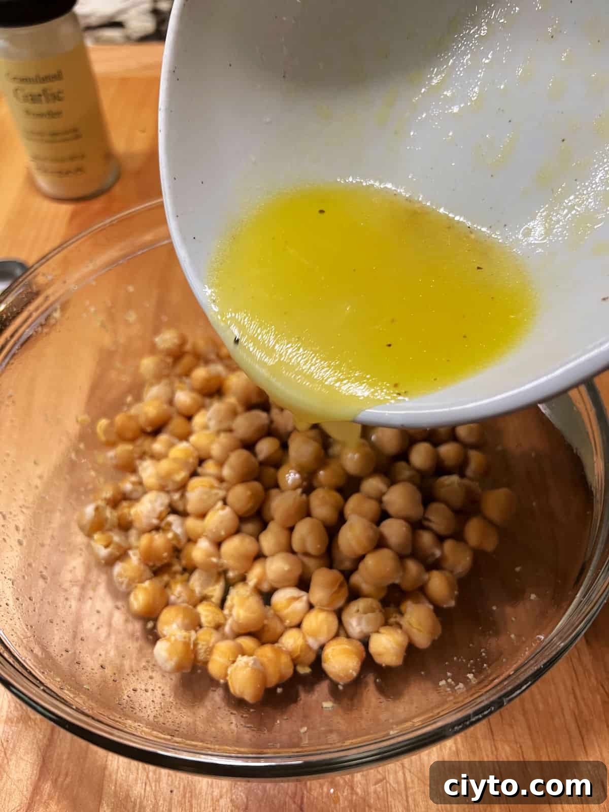 Chickpea and Avocado Salad Recipe 4 Pouring the dressing over the hot chickpeas.