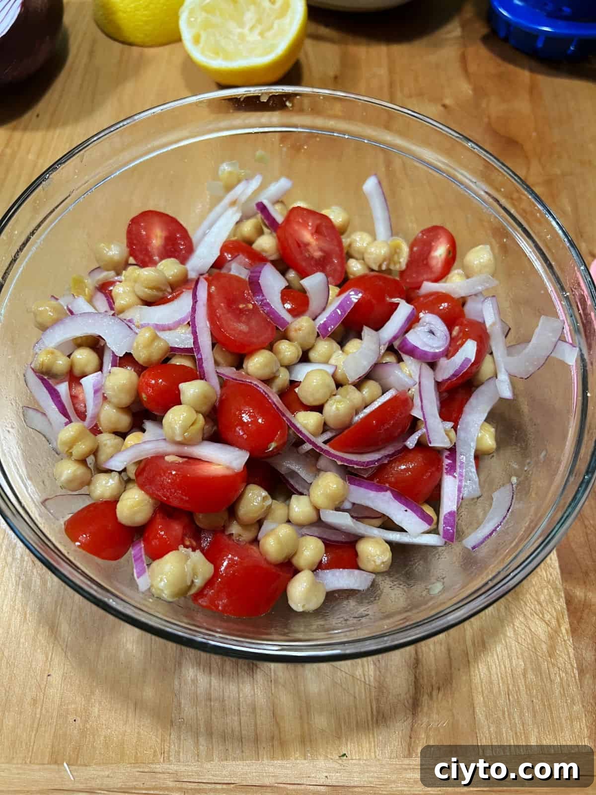 Chickpea and Avocado Salad Recipe 5 Marinated chickpeas, tomatoes, and onion mixed in the bowl.